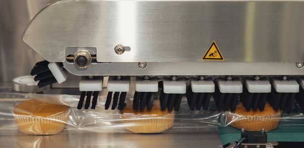 Automated packaging machine sealing baked goods